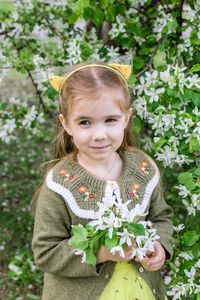 Portrait of cute girl standing against plants