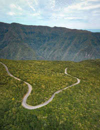 Scenic view of road by mountains against sky