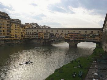 Bridge over river against cloudy sky