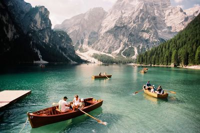 People on lake against mountains