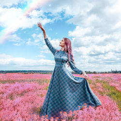 Woman standing on field against sky