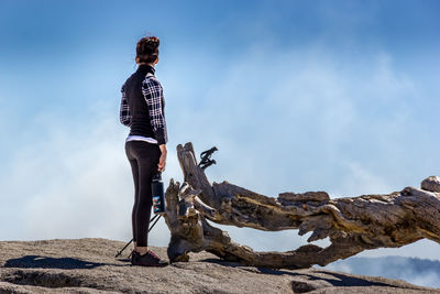 Low angle view of woman standing against sky