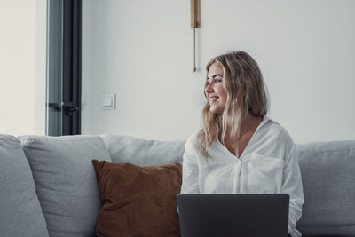 Portrait of woman using digital tablet while sitting at home