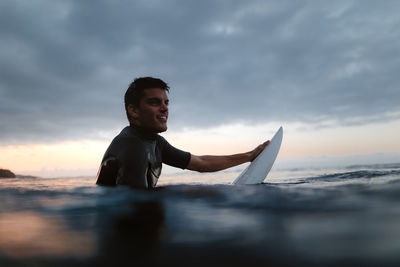 Boy on beach against sky during sunset