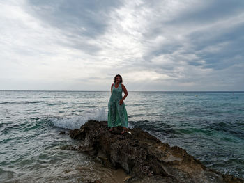 Woman standing on rock at beach 