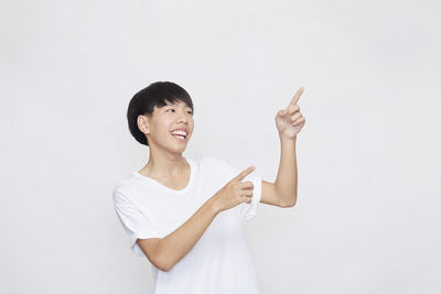 Portrait of smiling woman standing against white background