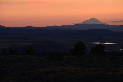 Scenic view of silhouette mountains against sky at sunset