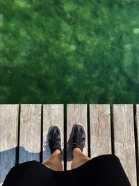 Low section of woman standing on pier over sea