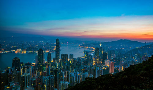 Illuminated cityscape against sky at night