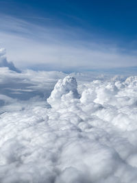 View from a airplane window to the white clouds and blue sky