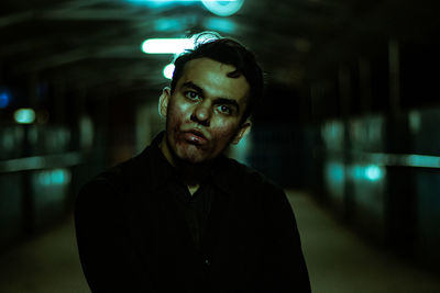 Portrait of young man standing in city at night