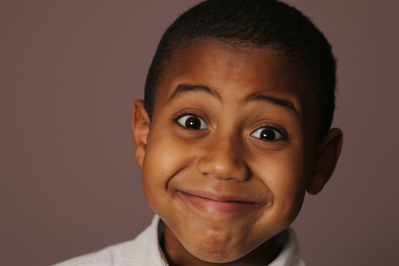 portrait, looking at camera, person, headshot, close-up, front view, indoors, studio shot, childhood, human face, lifestyles, young men, happiness, boys, smiling, head and shoulders, elementary age, focus on foreground