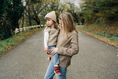 Portrait of young woman standing on road