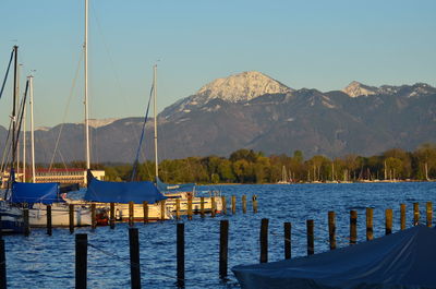 Sailboats moored on lake against clear sky