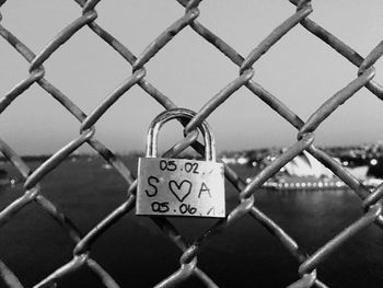 Close-up of padlocks on chainlink fence