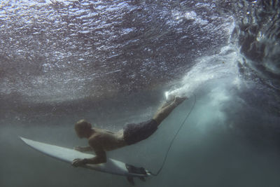 Surfer on surfboard, underwater shot