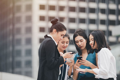 Young woman using mobile phone in city