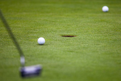 Close-up of golf club and ball on field