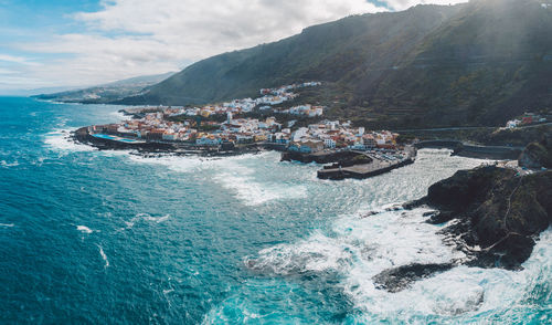 High angle view of sea by mountain against sky