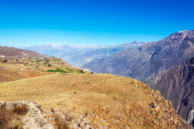 Scenic view of mountains against clear blue sky 