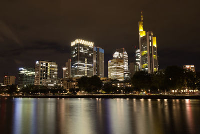 Illuminated buildings against sky at night