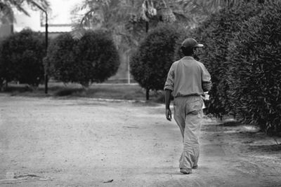 Rear view of man walking on road