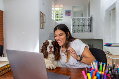 Portrait of young woman with dog on table