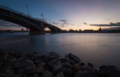 Bridge over river against sky during sunset