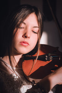 Close-up of young woman playing violin