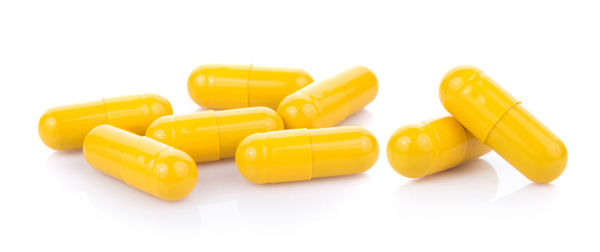 Panoramic view of yellow capsules over white background