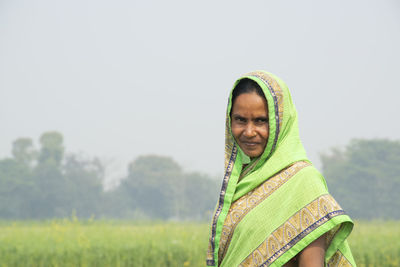 Portrait of a smiling young woman in sari at farm land