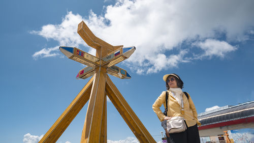 Low angle view of woman standing against sky