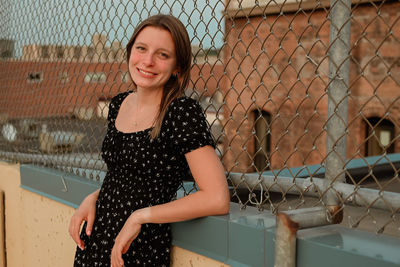 Portrait of young woman standing against wall