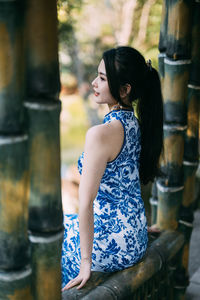 Young woman looking away while standing outdoors