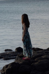 Side view of woman standing at beach