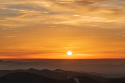 Scenic view of silhouette mountains against romantic sky at sunset