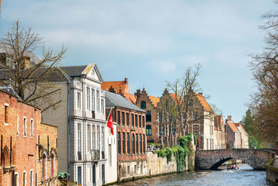 Canal amidst buildings in town against sky