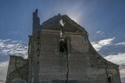 Low angle view of old temple against cloudy sky