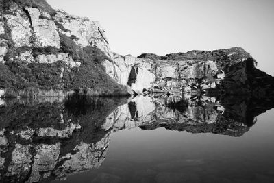 Scenic view of lake with rock formations reflection