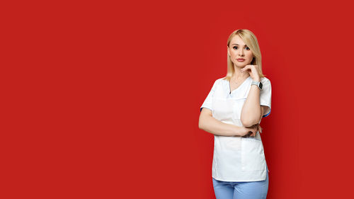 Portrait of a young woman against red background