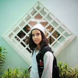 Portrait of beautiful young woman standing against built structure