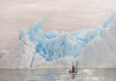 Man in boat on sea against sky