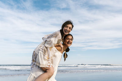 Portrait of smiling woman on beach against sky