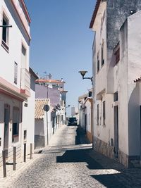 Alley amidst buildings in town against sky