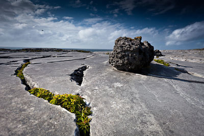 Rock on rocky field against sky