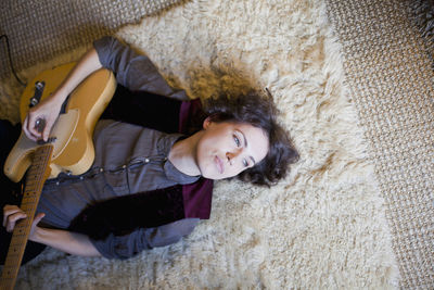 High angle portrait of smiling woman lying on floor