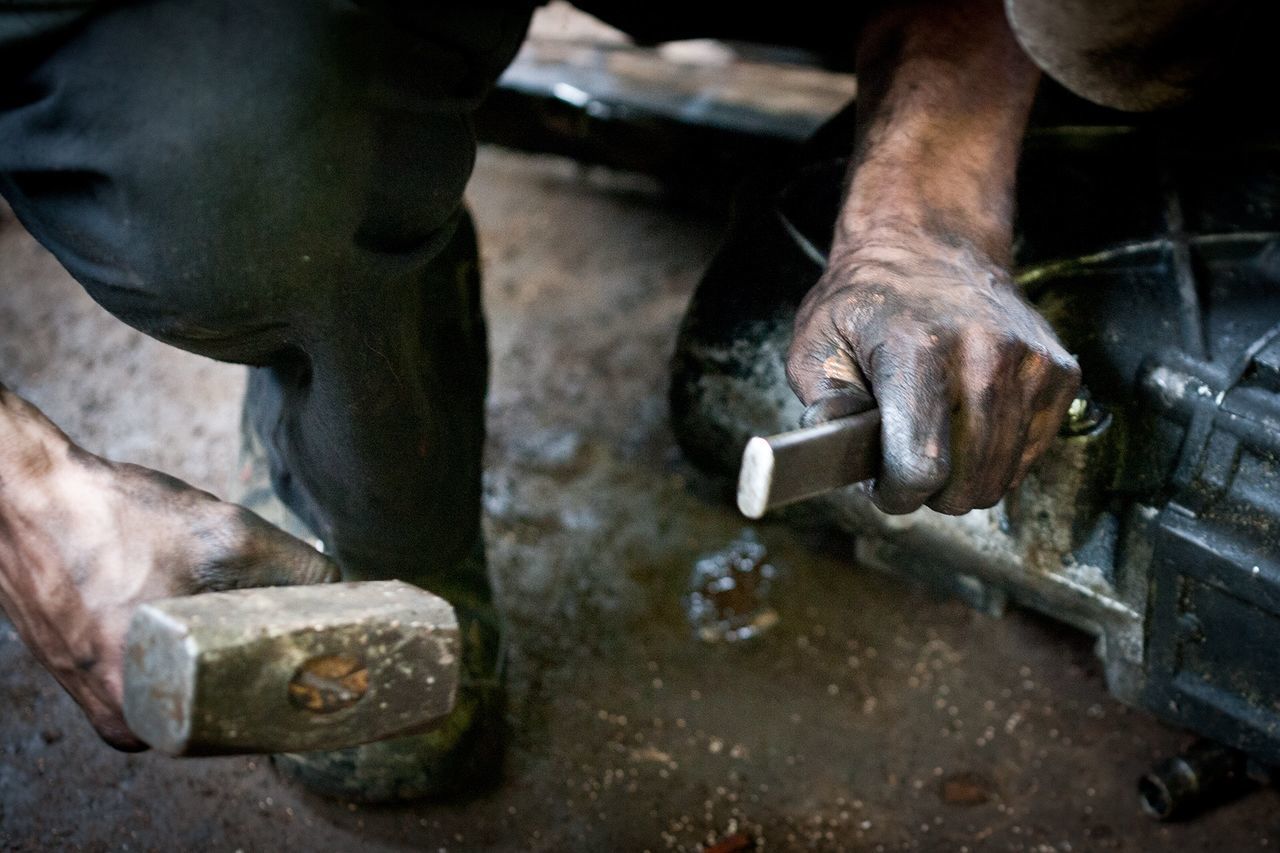 MIDSECTION OF MAN WORKING ON METAL