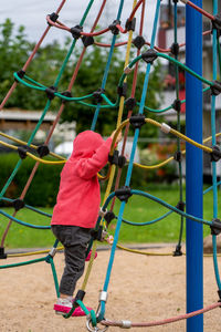 A small child on the jungle gym with net in a playground