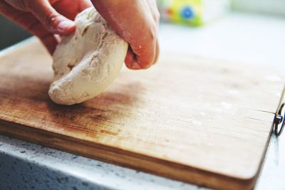 Close-up of person preparing dough on cutting board