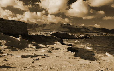 Rocky mountains by sea against sky